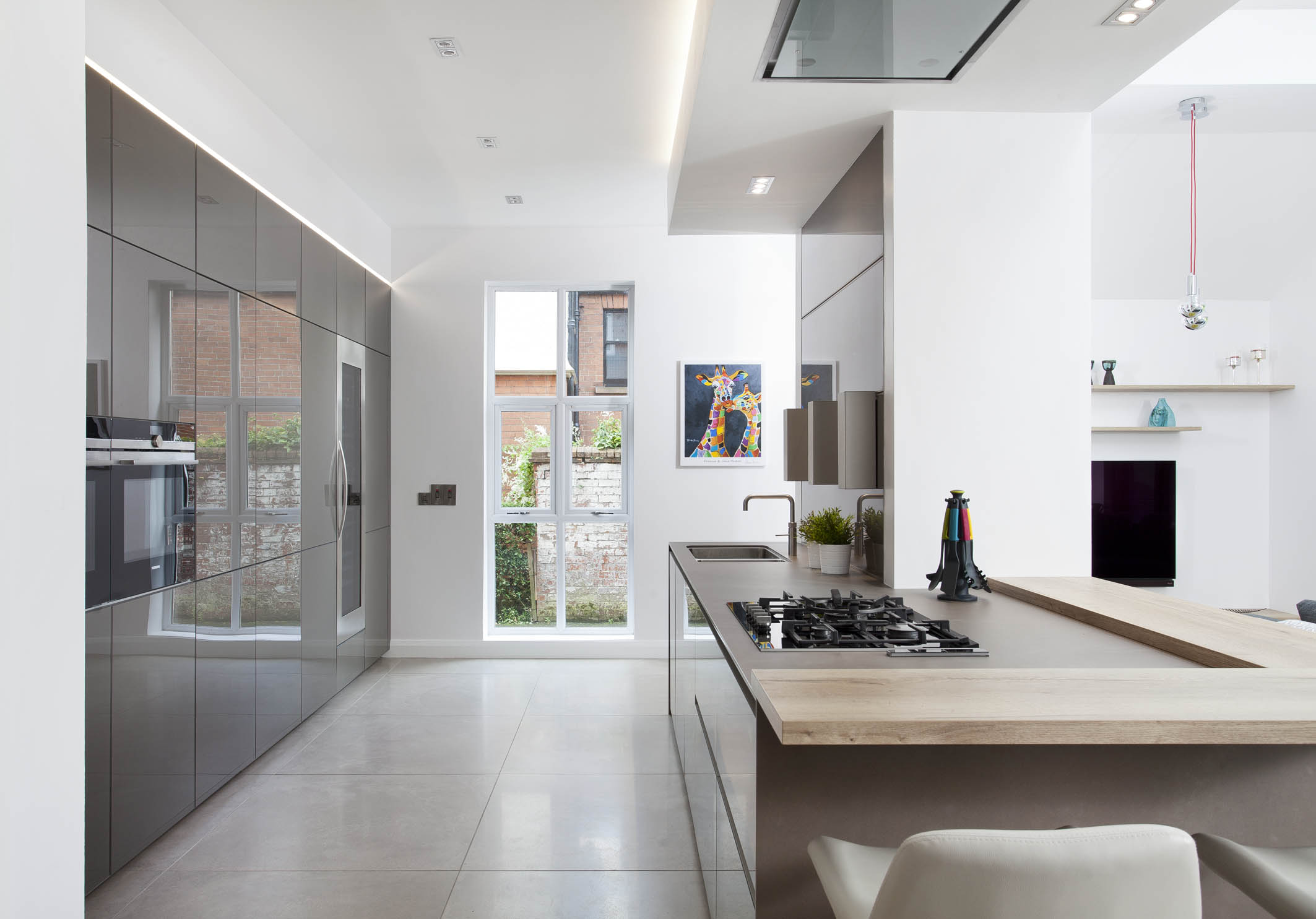 White hi gloss kitchen with coffee station and hidden utility