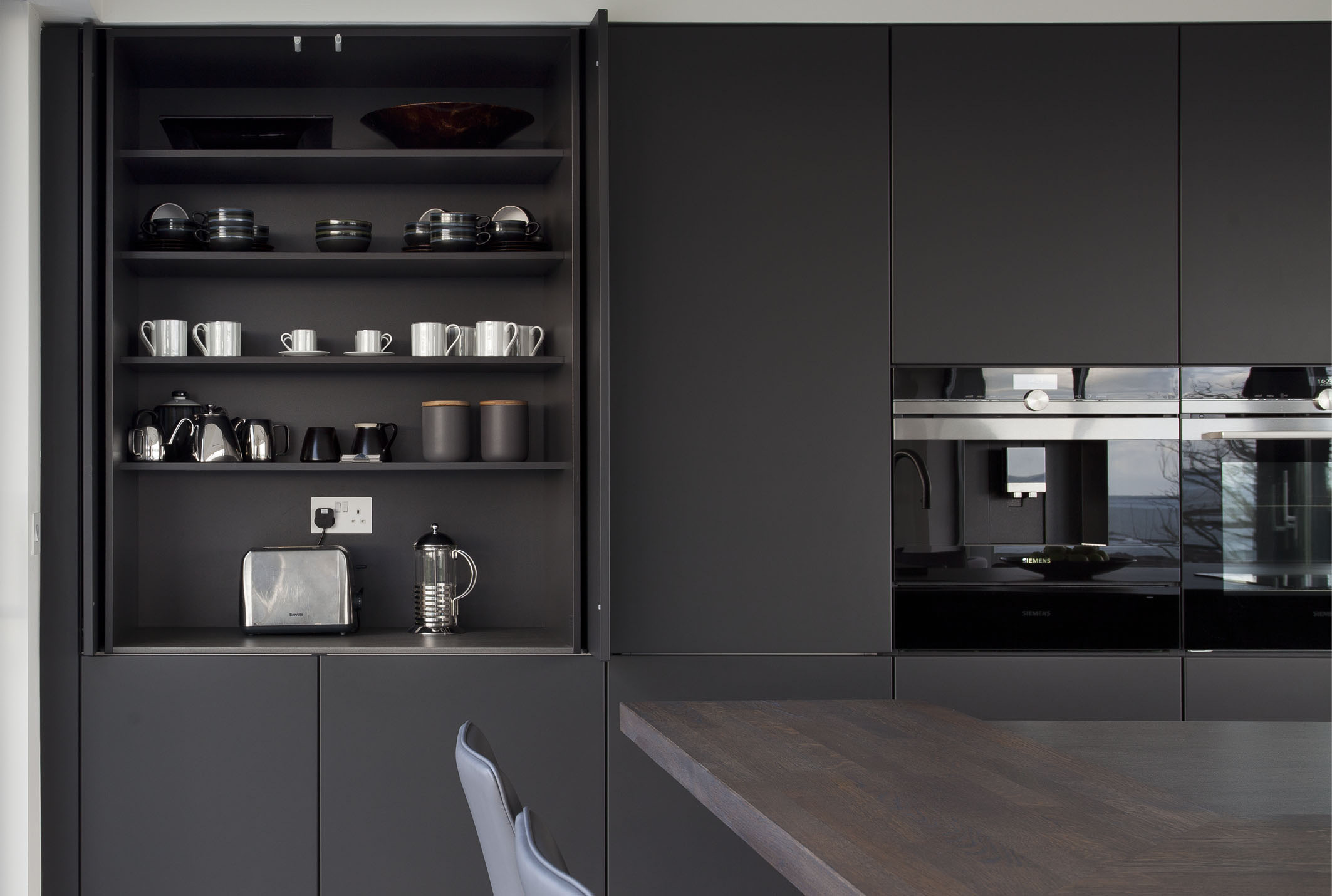 White hi gloss kitchen with coffee station and hidden utility